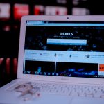 Laptop on a desk showing the Pexels homepage, highlighting its web interface.